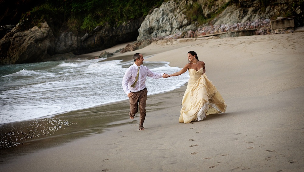 bride and groom running on the beach in mexico 