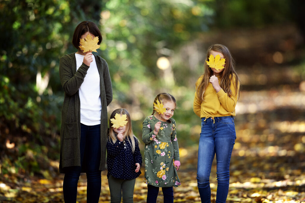 girls with leaves for a blog post idea for family portrait photographers