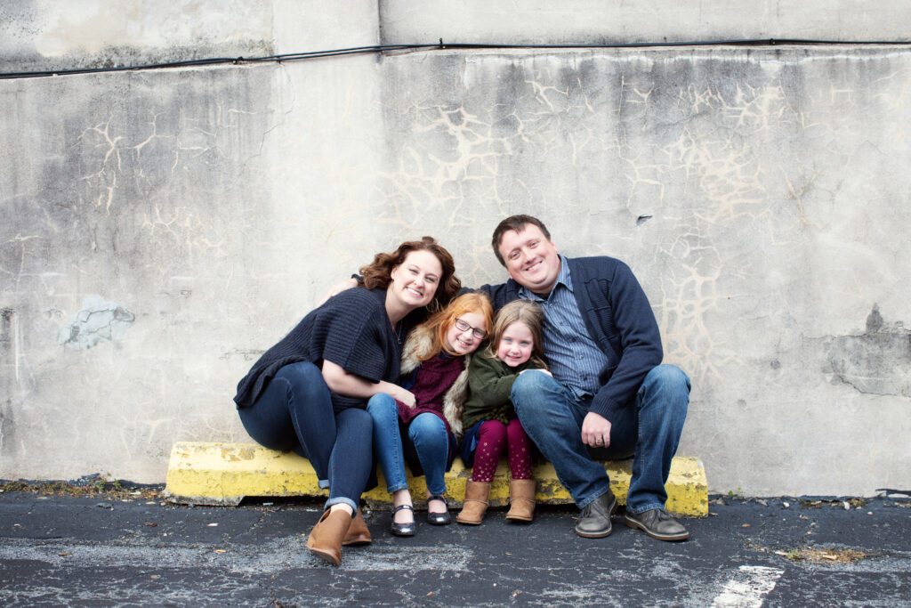 cute family casually sitting smiling at the camera in a candid moment