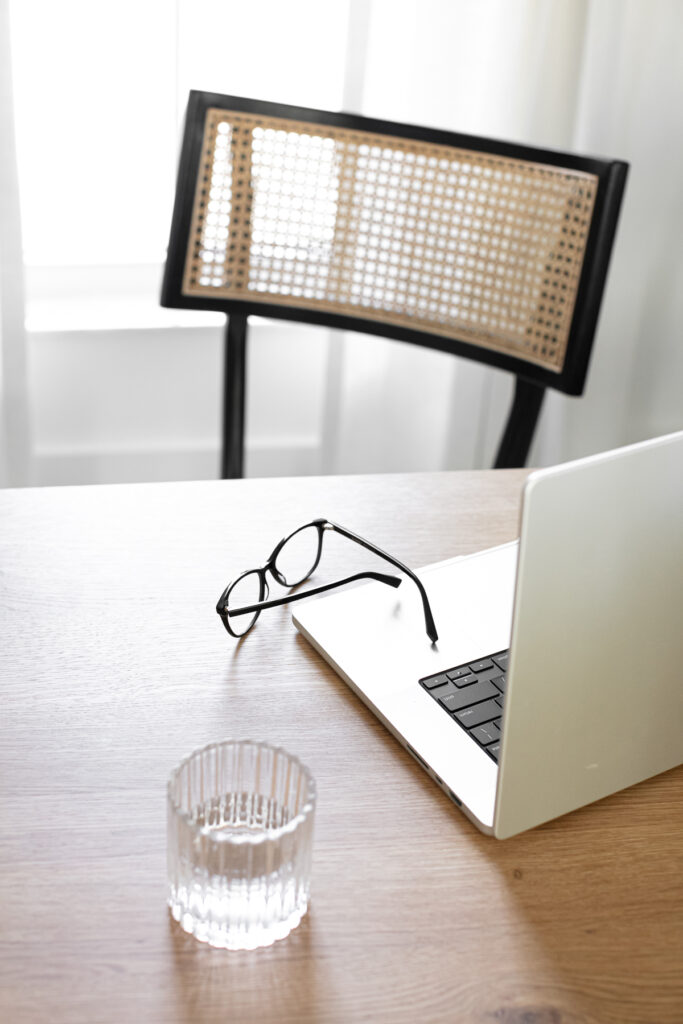 an open laptop with glasses sitting nearby for topic research on mastering the art of blogging 